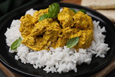 Photo of Delicious rice and chicken with curry sauce on plate, closeup