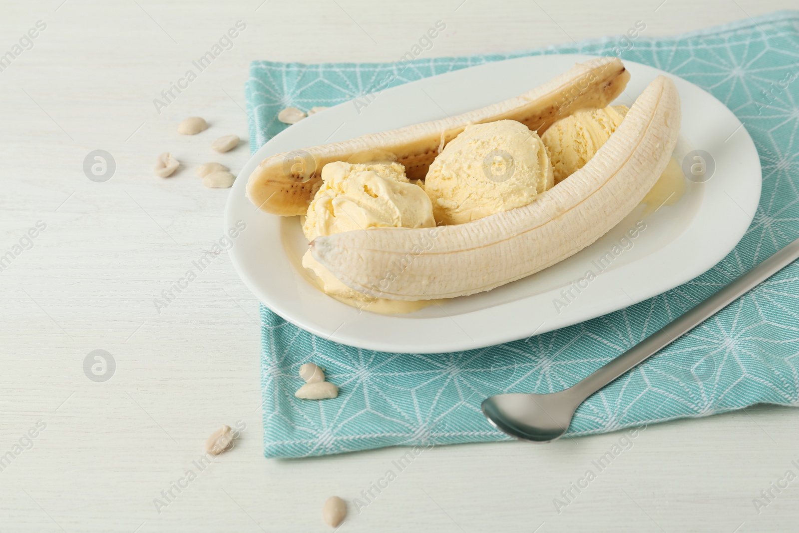 Photo of Delicious banana split ice cream on white wooden table