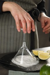 Woman making delicious Margarita cocktail at grey table, closeup