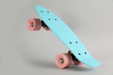 Turquoise skateboard on light grey background. Sport equipment