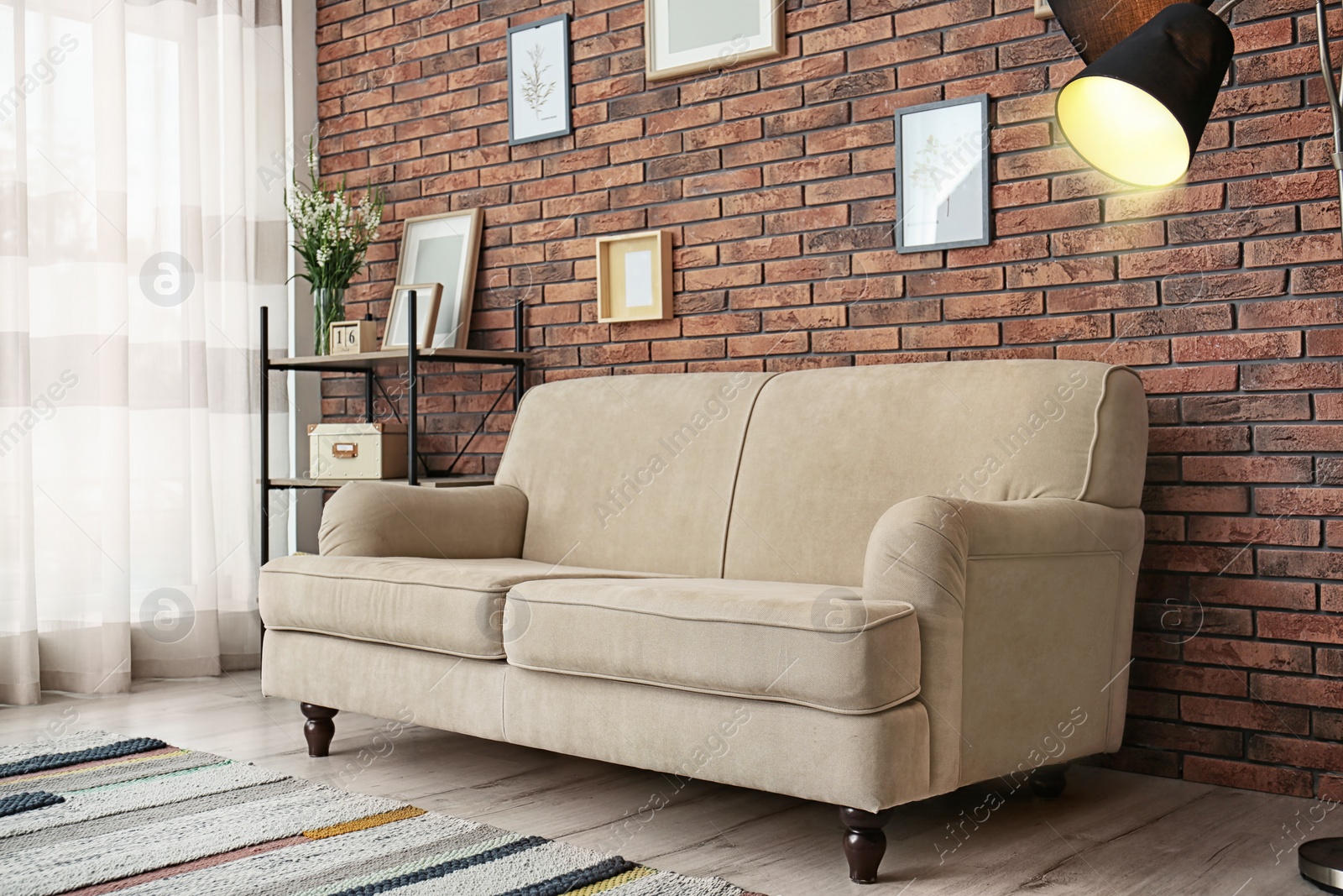 Photo of Modern living room interior with comfortable sofa near brick wall