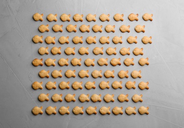 Delicious goldfish crackers on grey table, flat lay