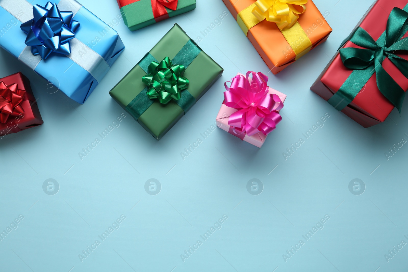 Photo of Many colorful gift boxes on light blue background, flat lay. Space for text