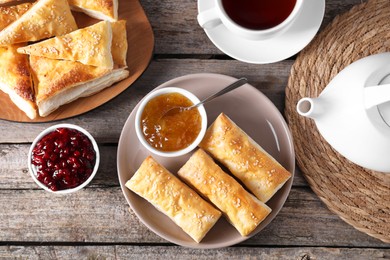 Photo of Delicious puff pastry served on wooden table, flat lay