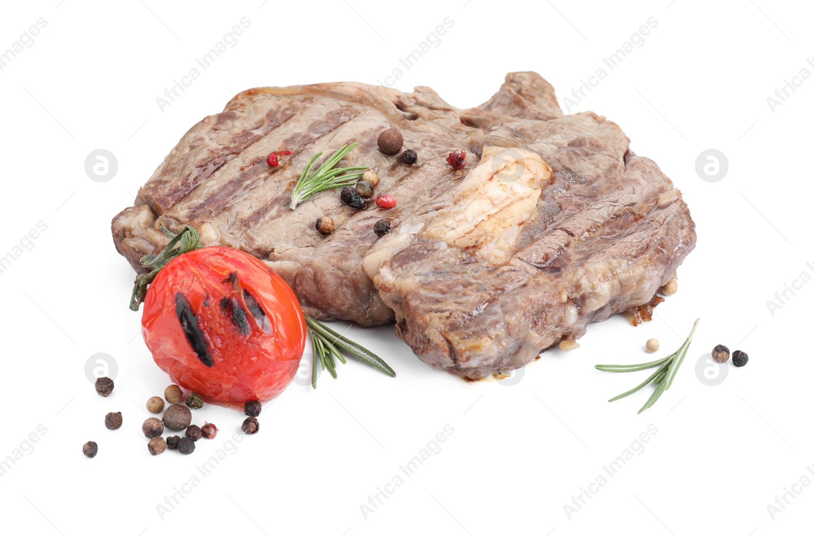 Photo of Piece of delicious grilled beef meat, rosemary, tomato and peppercorns isolated on white