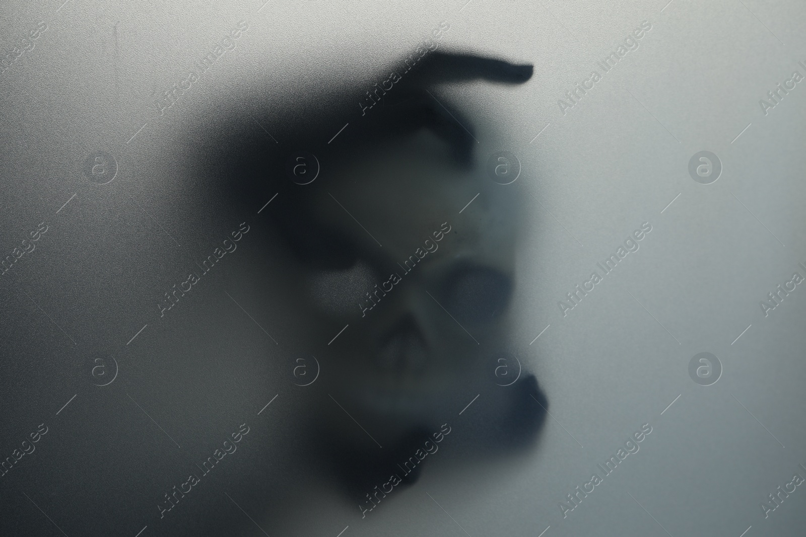 Photo of Silhouette of creepy ghost with skull behind cloth