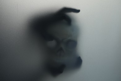 Photo of Silhouette of creepy ghost with skull behind cloth