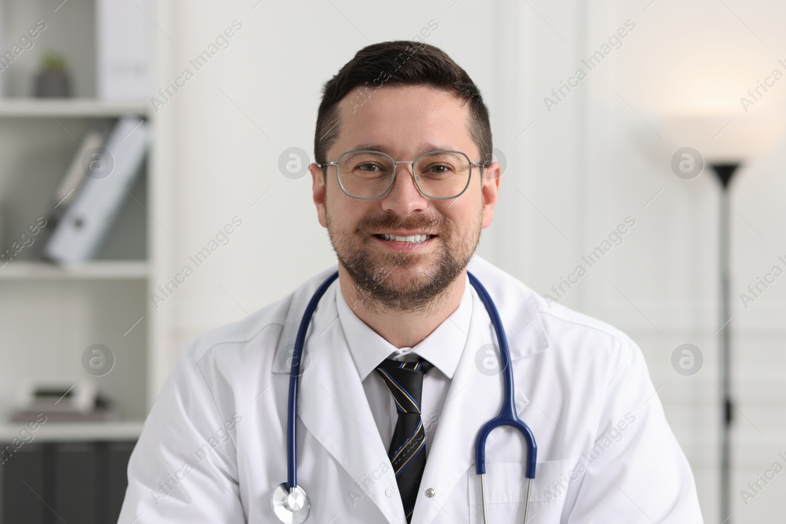 Photo of Portrait of smiling doctor with stethoscope indoors