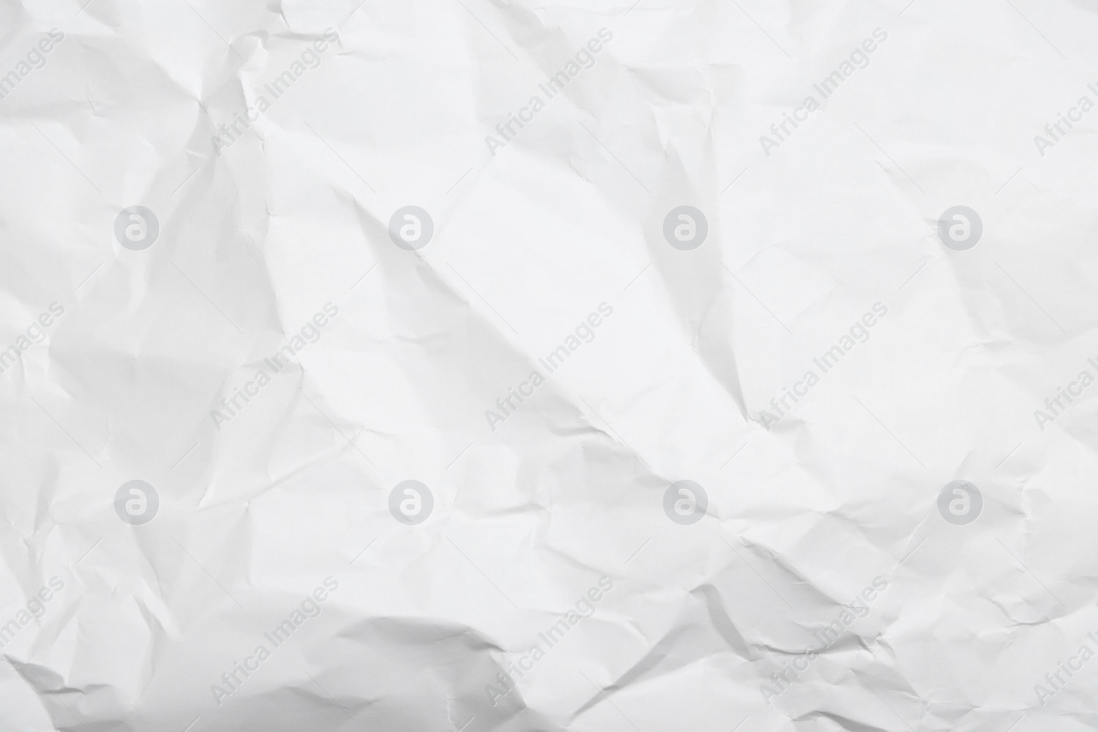 Photo of Sheet of white crumpled paper as background, closeup