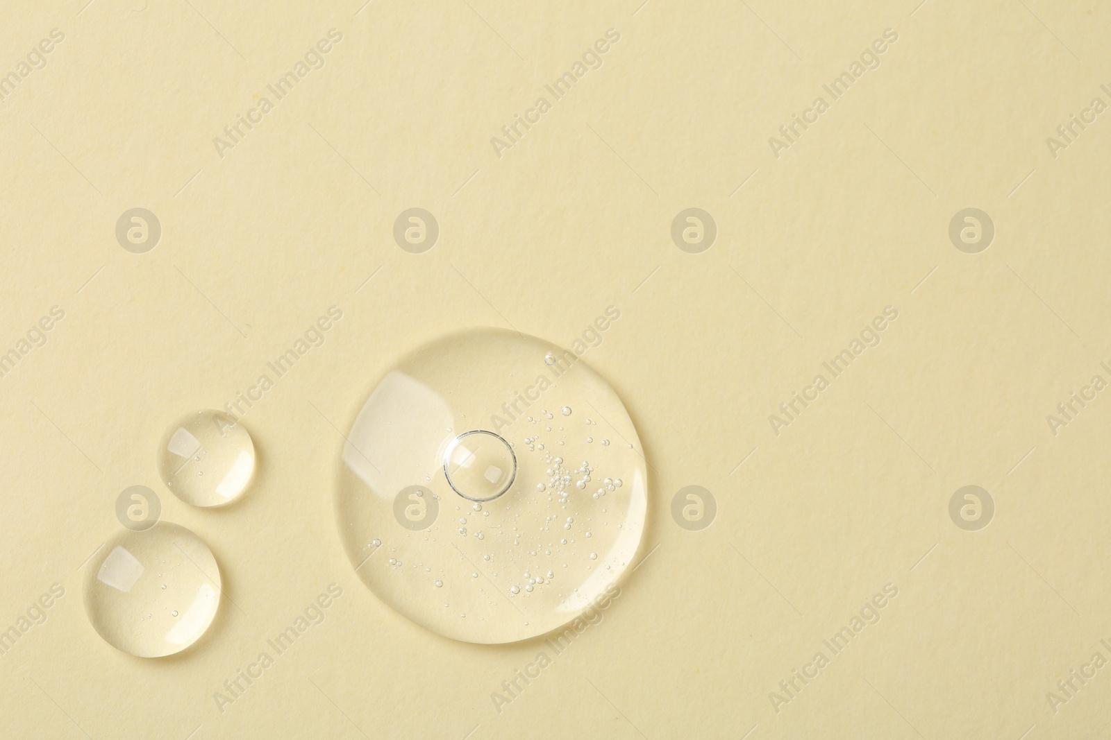 Photo of Samples of cosmetic serum on beige background, flat lay. Space for text