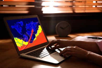 Image of Woman analyzing situation on international market via laptop, closeup. World map and charts on screen