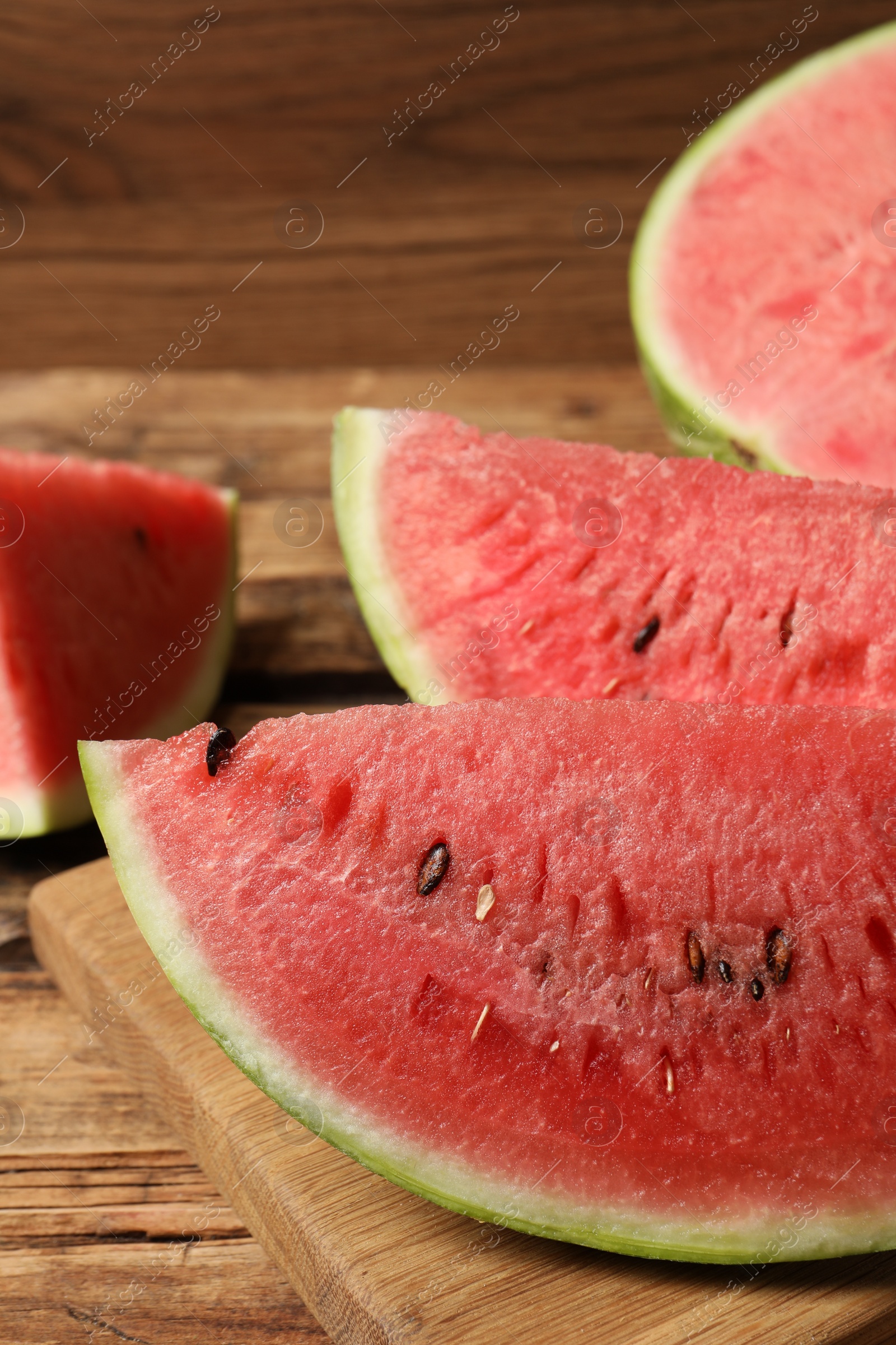 Photo of Slices of tasty ripe watermelon on wooden table, closeup