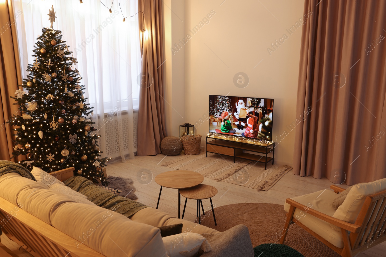 Photo of Wide TV set, furniture and Christmas tree in stylish room