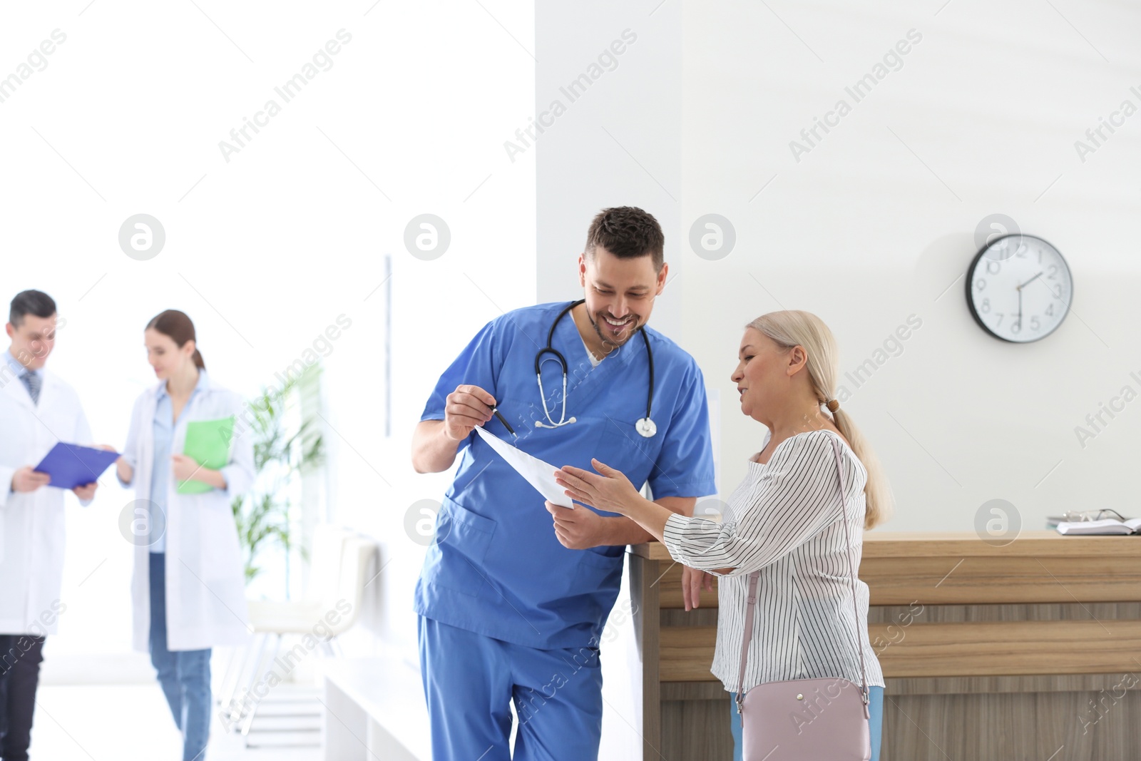 Photo of Doctor talking with patient in hospital hall