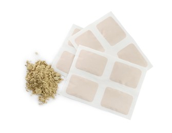 Photo of Mustard powder and plasters on white background, top view
