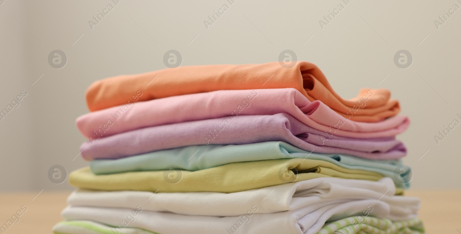 Photo of Stack of clean clothes on wooden table