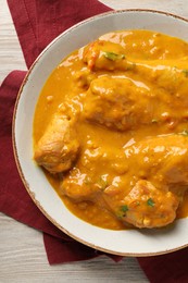 Tasty chicken curry on wooden table, top view