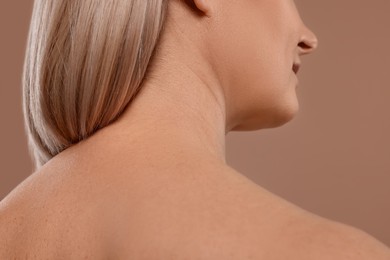 Back view of woman with healthy skin on beige background, closeup