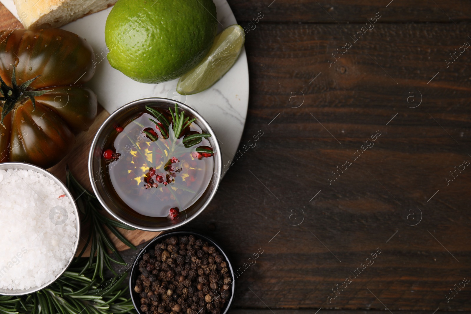 Photo of Tasty fish marinade with rosemary in bowl and products on wooden table, flat lay. Space for text