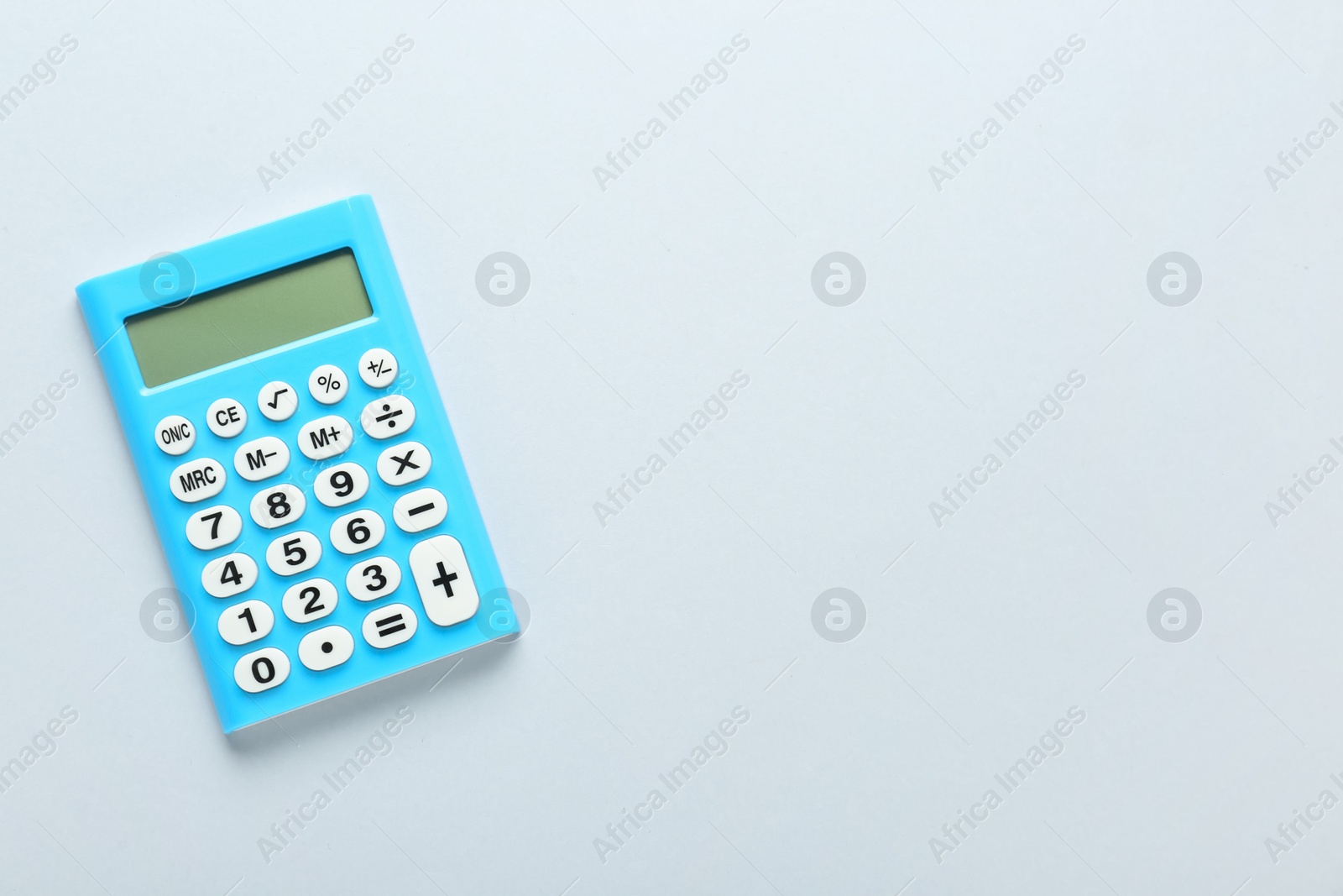 Photo of Light blue calculator on light background, top view. Space for text