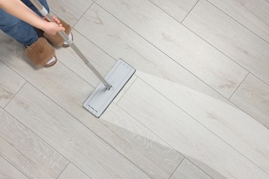 Image of Woman washing floor with mop indoors, top view. Clean trace on dirty surface