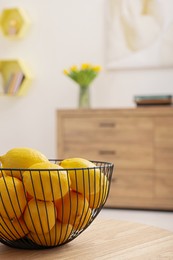 Photo of Spring interior. Bowl of lemons on wooden table in room, closeup with space for text
