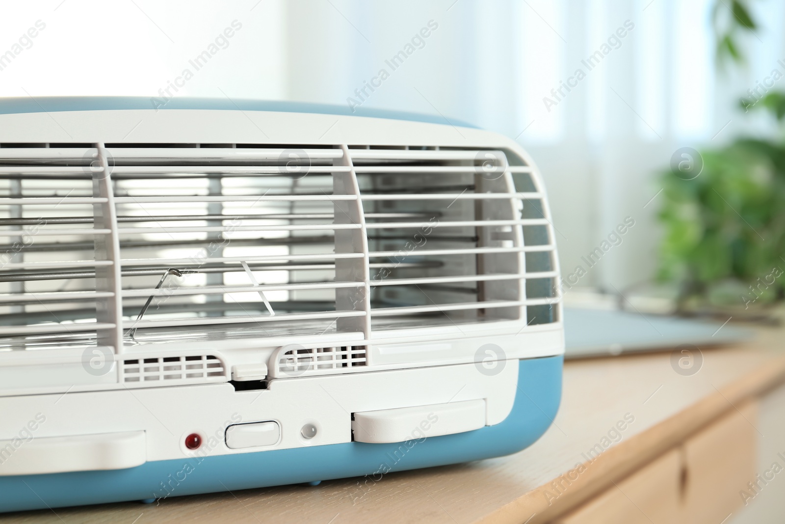 Photo of Modern air purifier on wooden table in room, closeup