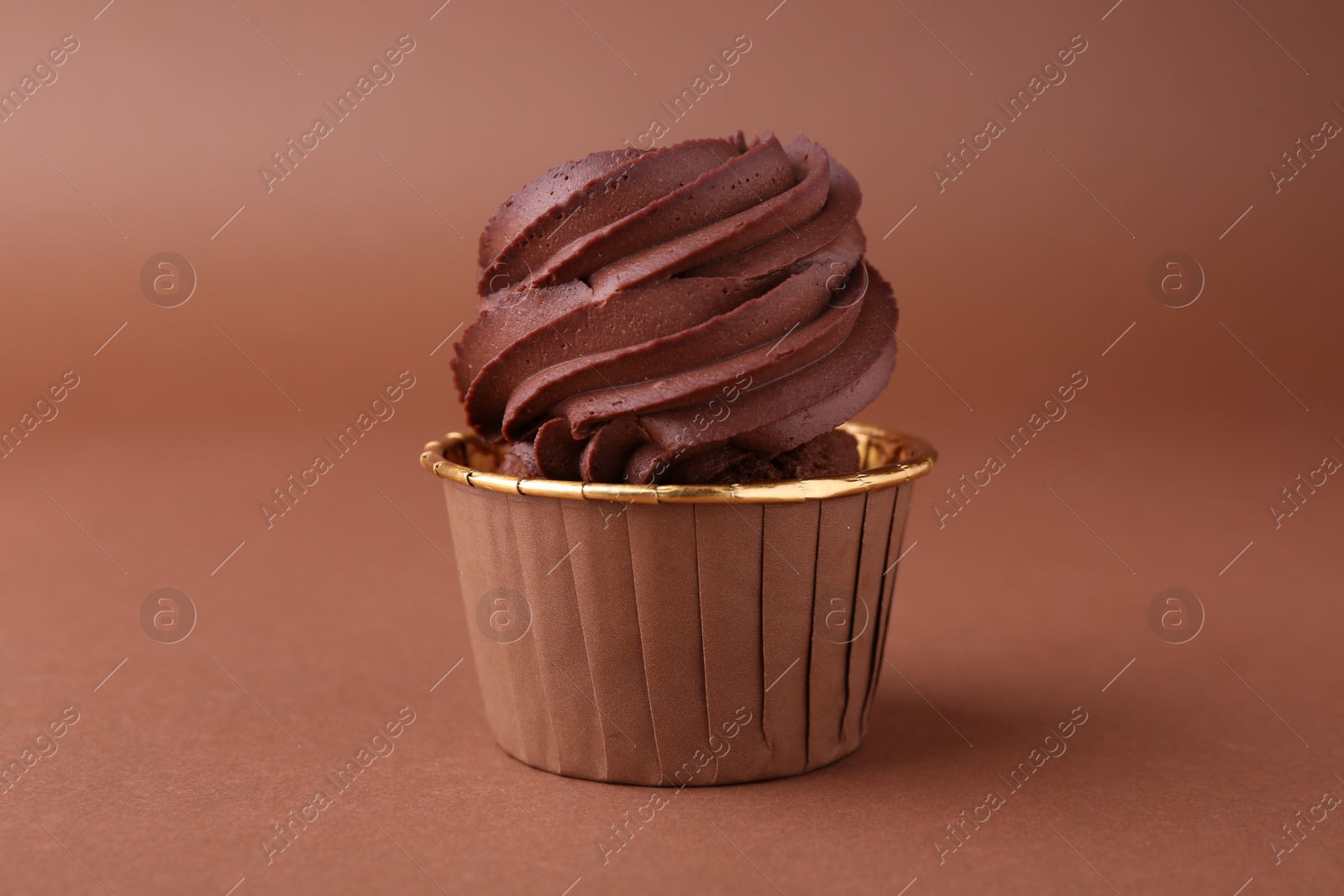 Photo of Delicious chocolate cupcake on brown background, closeup