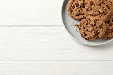 Photo of Delicious chocolate chip cookies on white wooden table, top view. Space for text