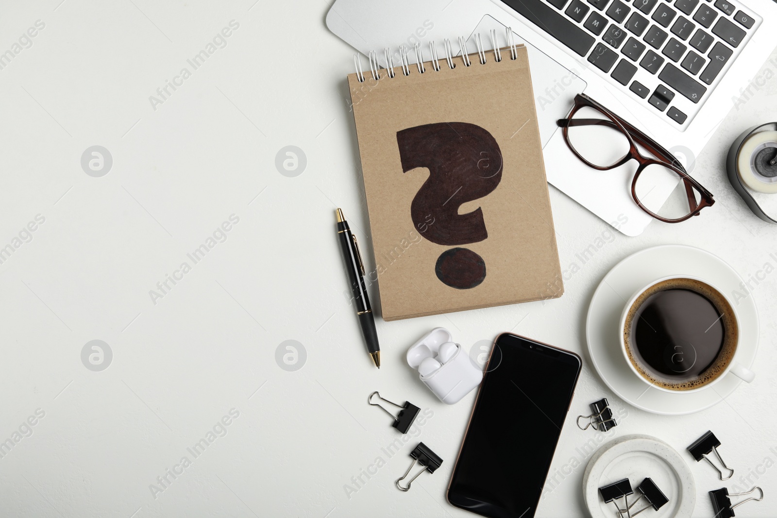 Photo of Notebook with question mark, laptop and cup of coffee on white table, flat lay. Space for text