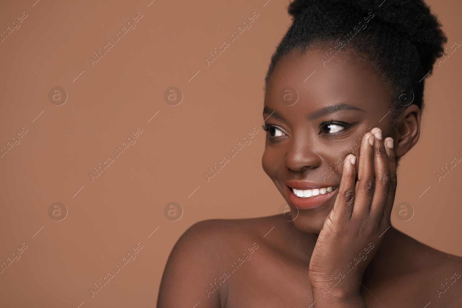 Photo of Portrait of beautiful happy woman on light brown background, space for text