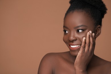 Photo of Portrait of beautiful happy woman on light brown background, space for text