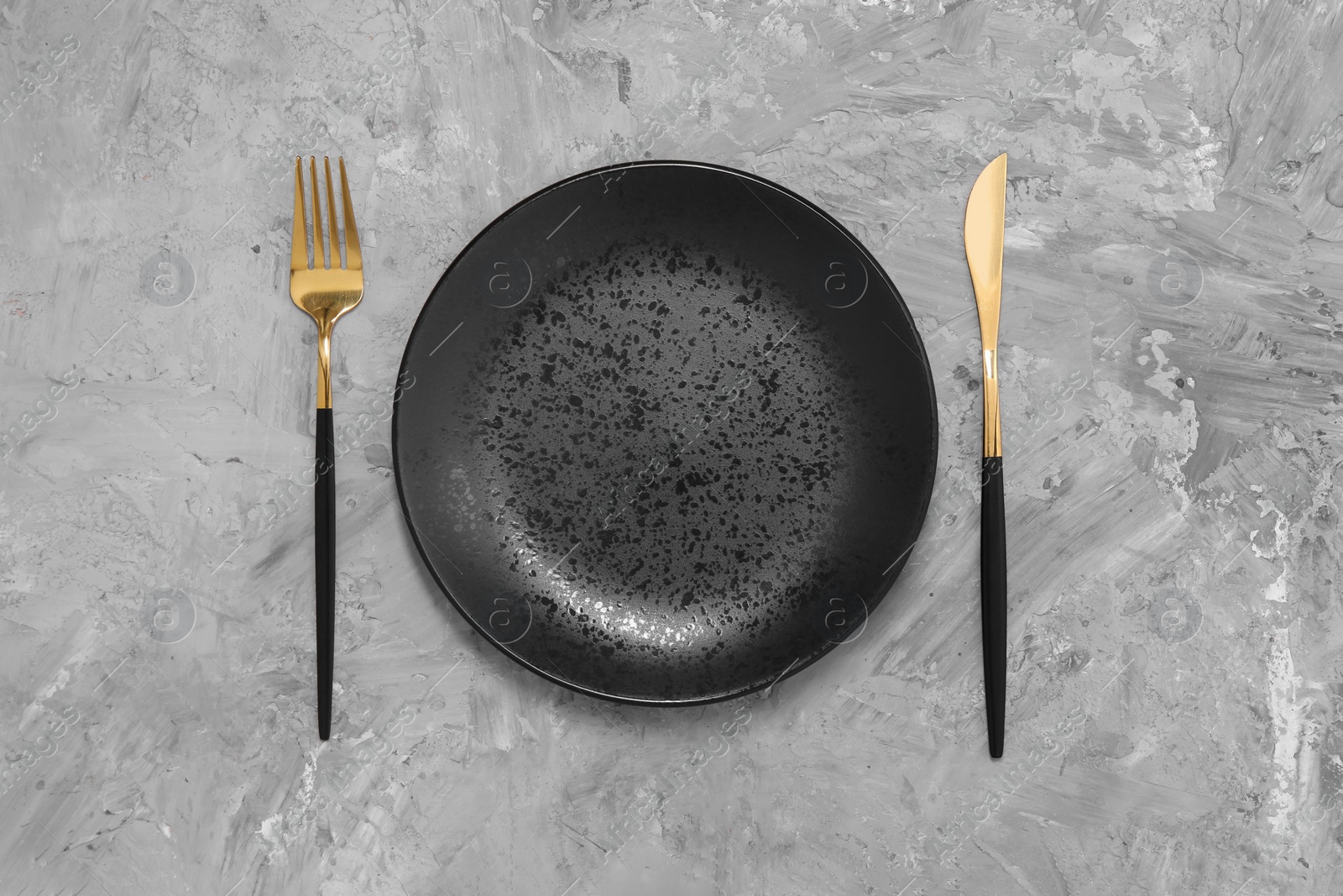 Photo of Elegant setting with shiny cutlery on grey table, top view