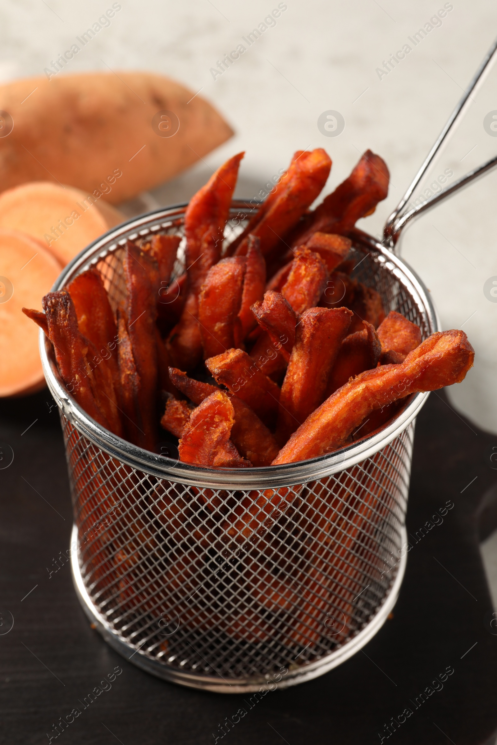 Photo of Sweet potato fries on wooden board, closeup