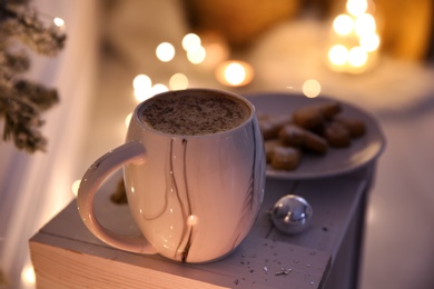 Photo of Cup of tasty hot drink and cookies indoors, closeup. Christmas atmosphere