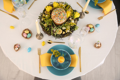 Festive Easter table setting with beautiful floral decor and eggs, top view