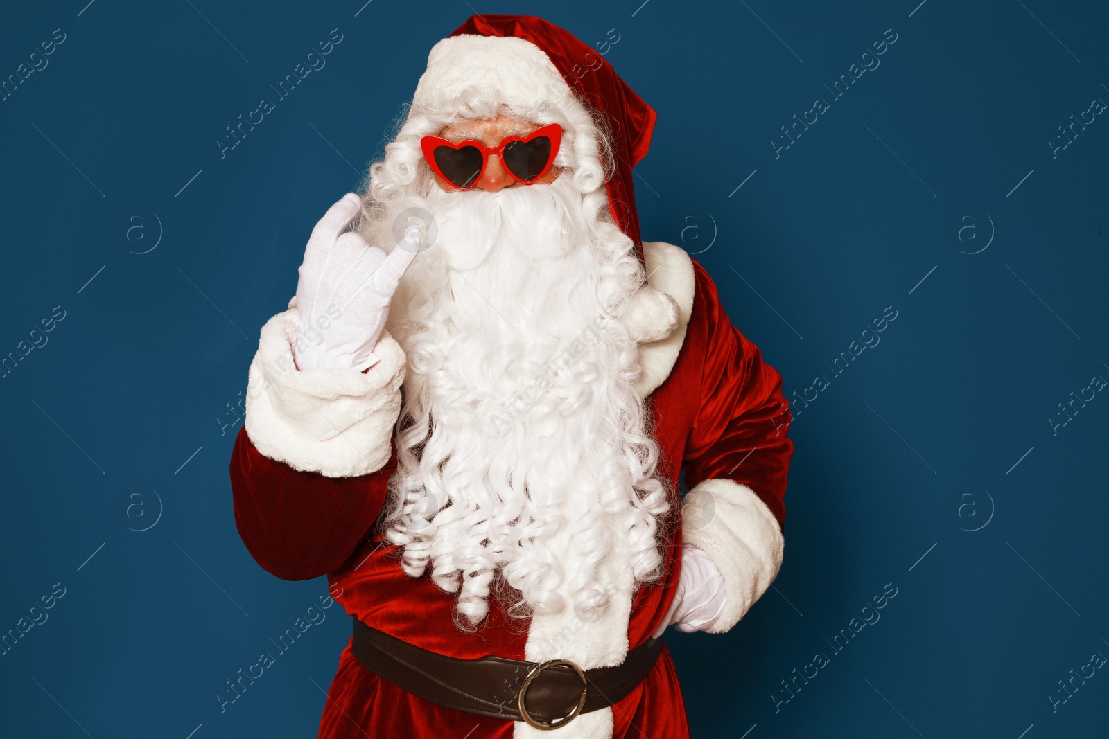 Photo of Authentic Santa Claus wearing sunglasses on blue background