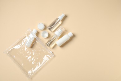 Photo of Cosmetic travel kit and plastic bag on beige background, flat lay with space for text. Bath accessories