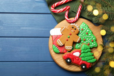 Photo of Different tasty Christmas cookies and decor on blue wooden table, flat lay. Space for text