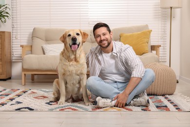 Photo of Man hugging with adorable Labrador Retriever dog at home. Lovely pet