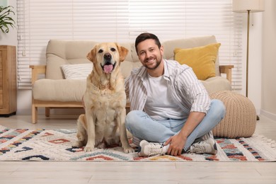 Man hugging with adorable Labrador Retriever dog at home. Lovely pet