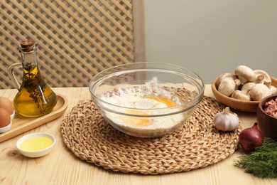 Photo of Bowl with flour, eggs and products on wooden table