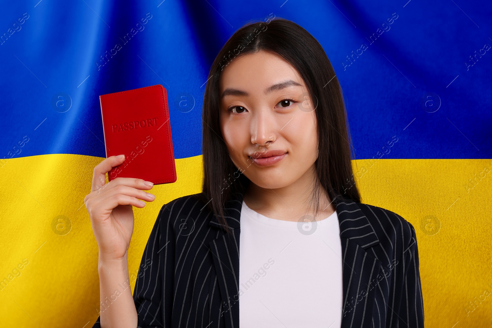 Image of Immigration. Woman with passport against national flag of Ukraine