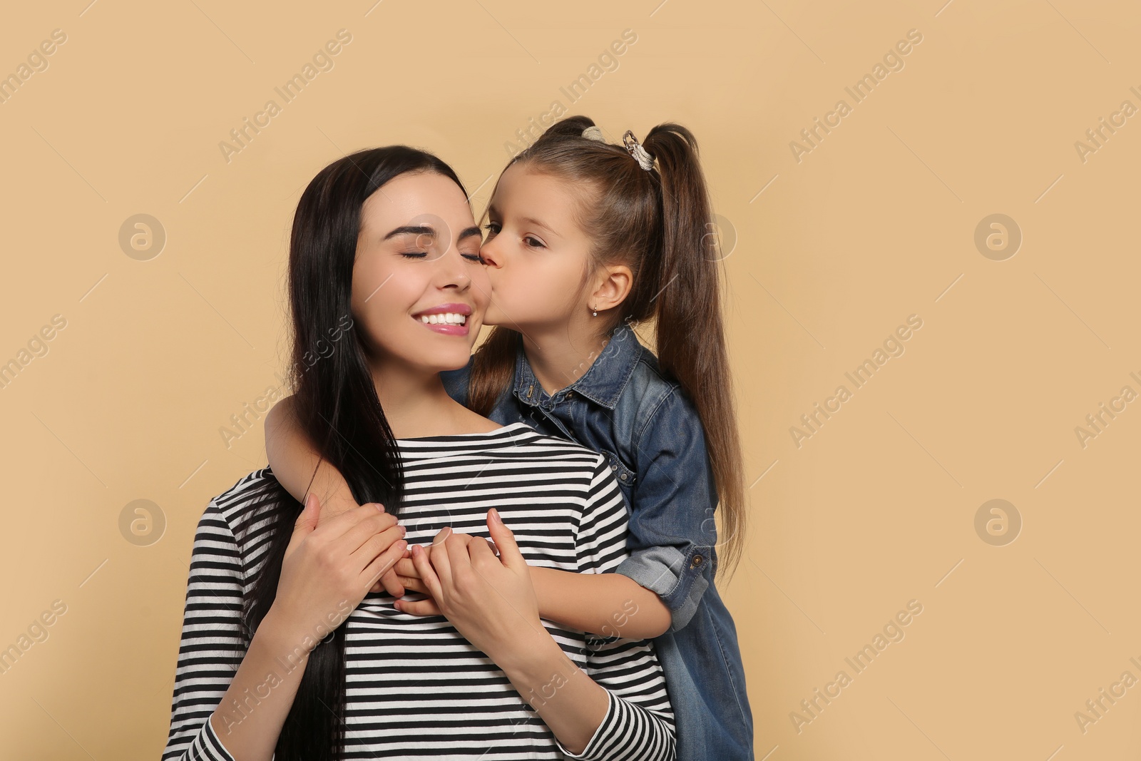 Photo of Happy woman with her daughter on beige background, space for text. Mother's day celebration