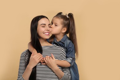 Happy woman with her daughter on beige background, space for text. Mother's day celebration