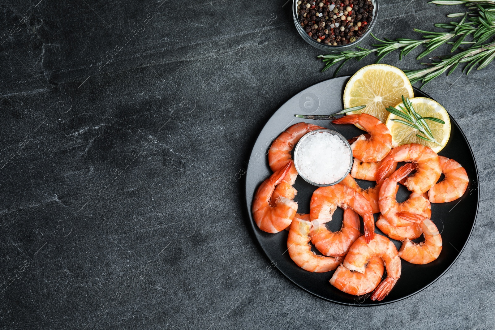 Photo of Delicious cooked shrimps with lemon and salt on dark grey table, flat lay. Space for text