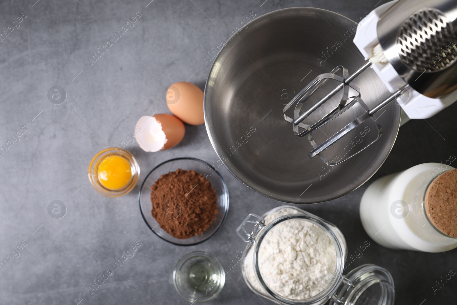 Photo of Stand mixer and different ingredients for dough on grey table, flat lay