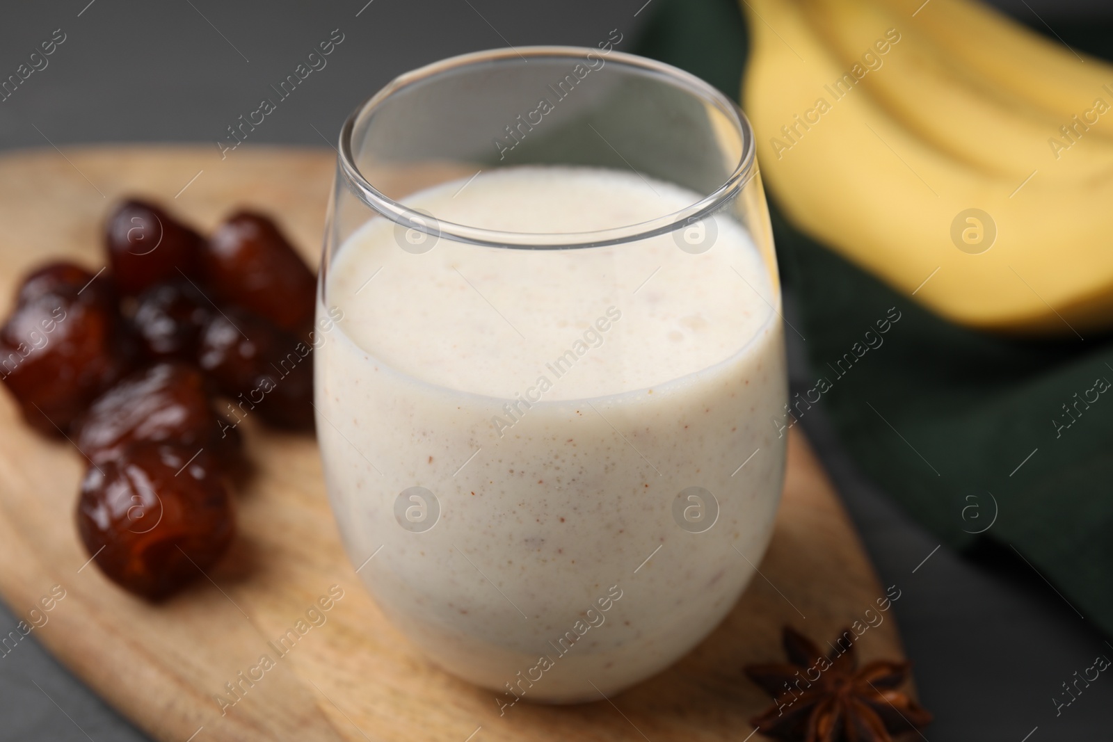 Photo of Glass of delicious date smoothie and dried fruits on table, closeup