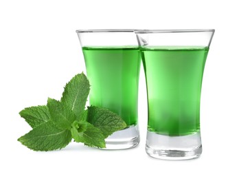 Photo of Delicious mint liqueur and fresh leaves on white background