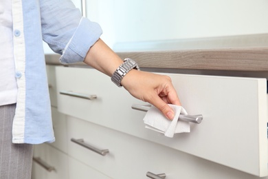 Woman using tissue paper to open drawer, closeup